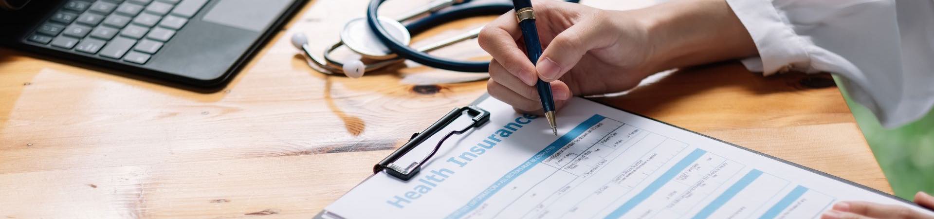 someone signing a health insurance document
