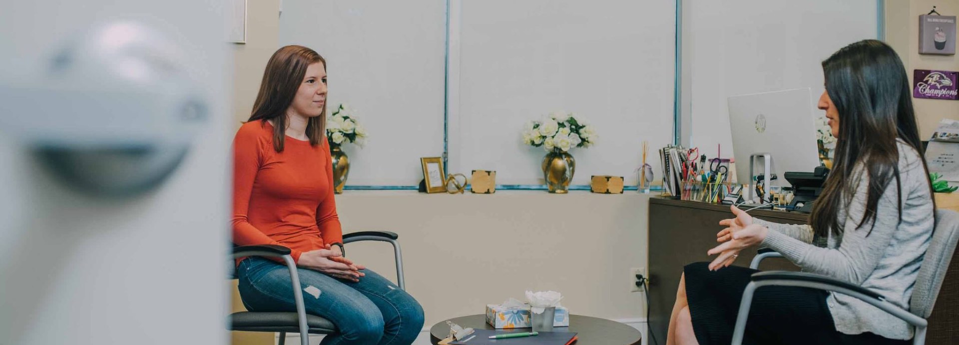 two woman sitting down consoling