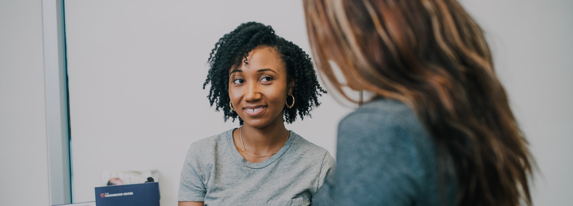 woman facing another woman smiling