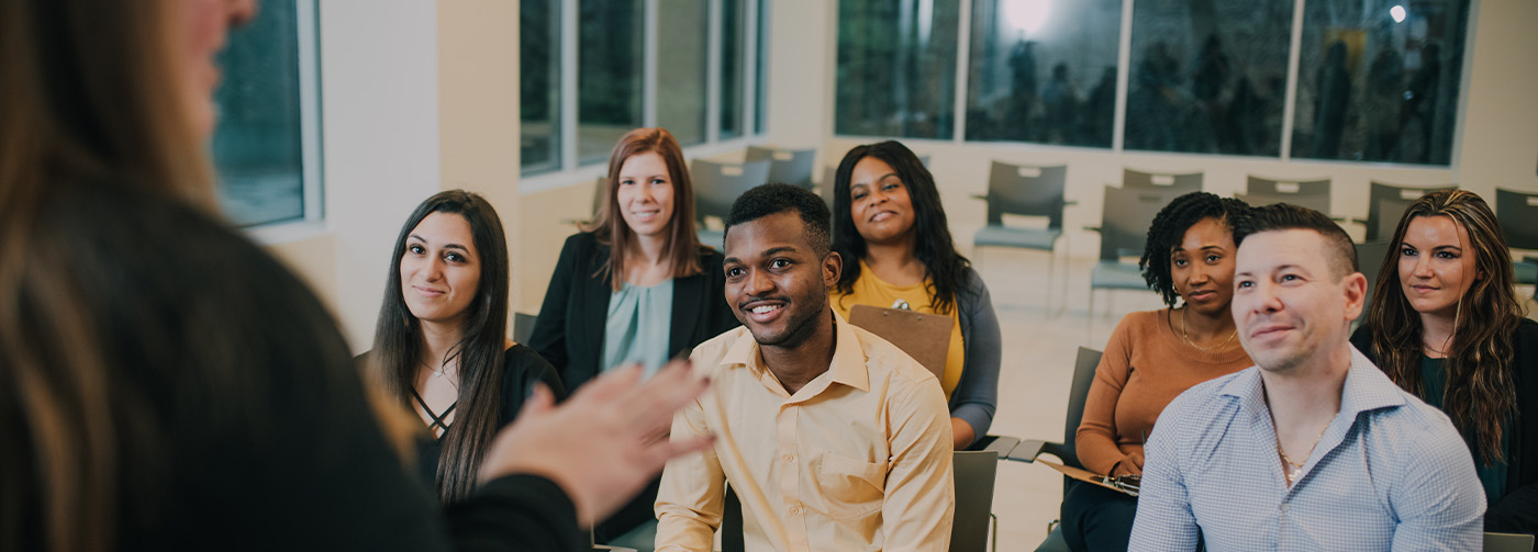 group of people sitting in a class room setting