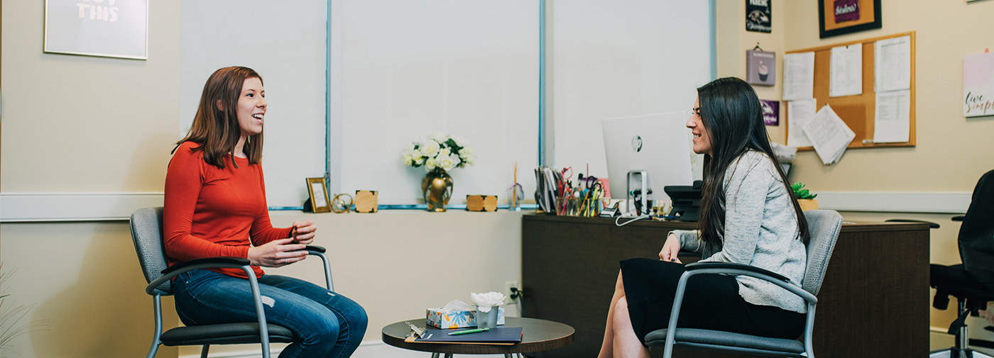 two women in a consoling room speaking with each other