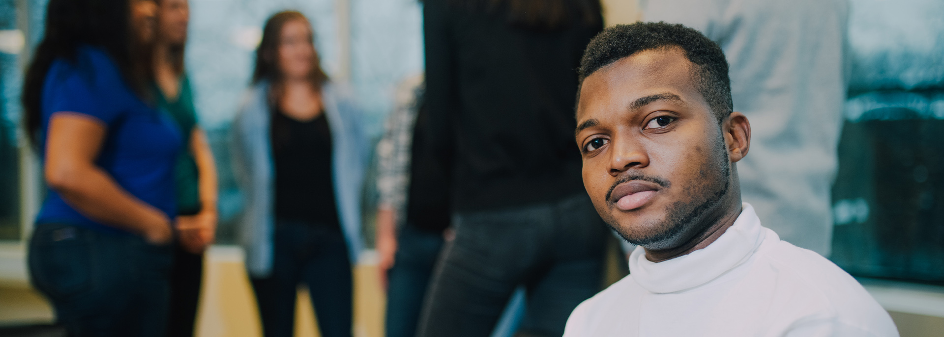 people meeting in a room and close up of man looking at the camera